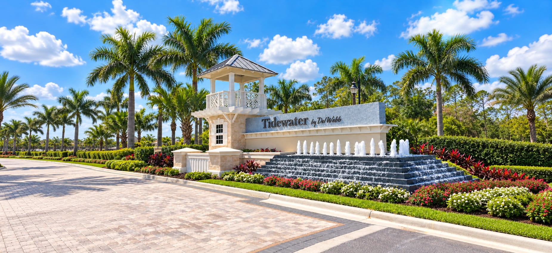 The Tidewater by Del Webb entrance sign in Estero, with a tiered fountain, royal palms and a gatehouse tower